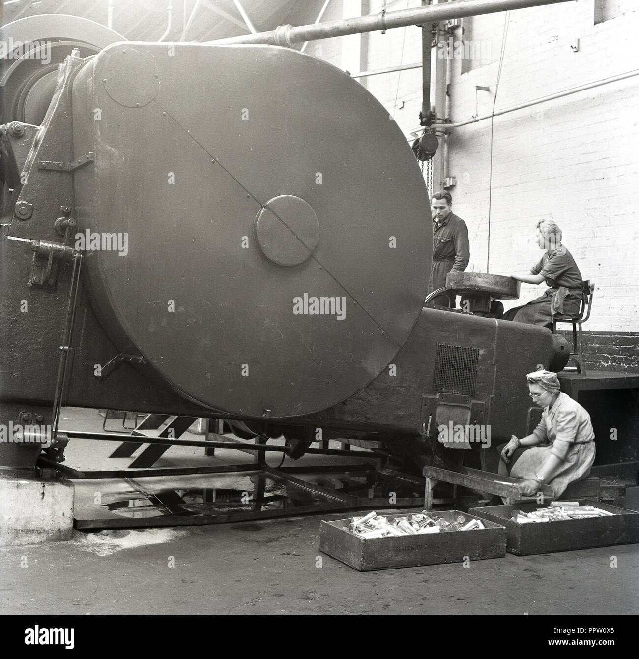 1950, historische, Frauen, die in der Fabrik der Brtish immer bereit, elektrische Co (GEREK), eines großen Metall verarbeitenden Maschine und einer anderen Erhebung der Prozess Rohre, Wald Rd, Walthamstwo, London, England. Stockfoto