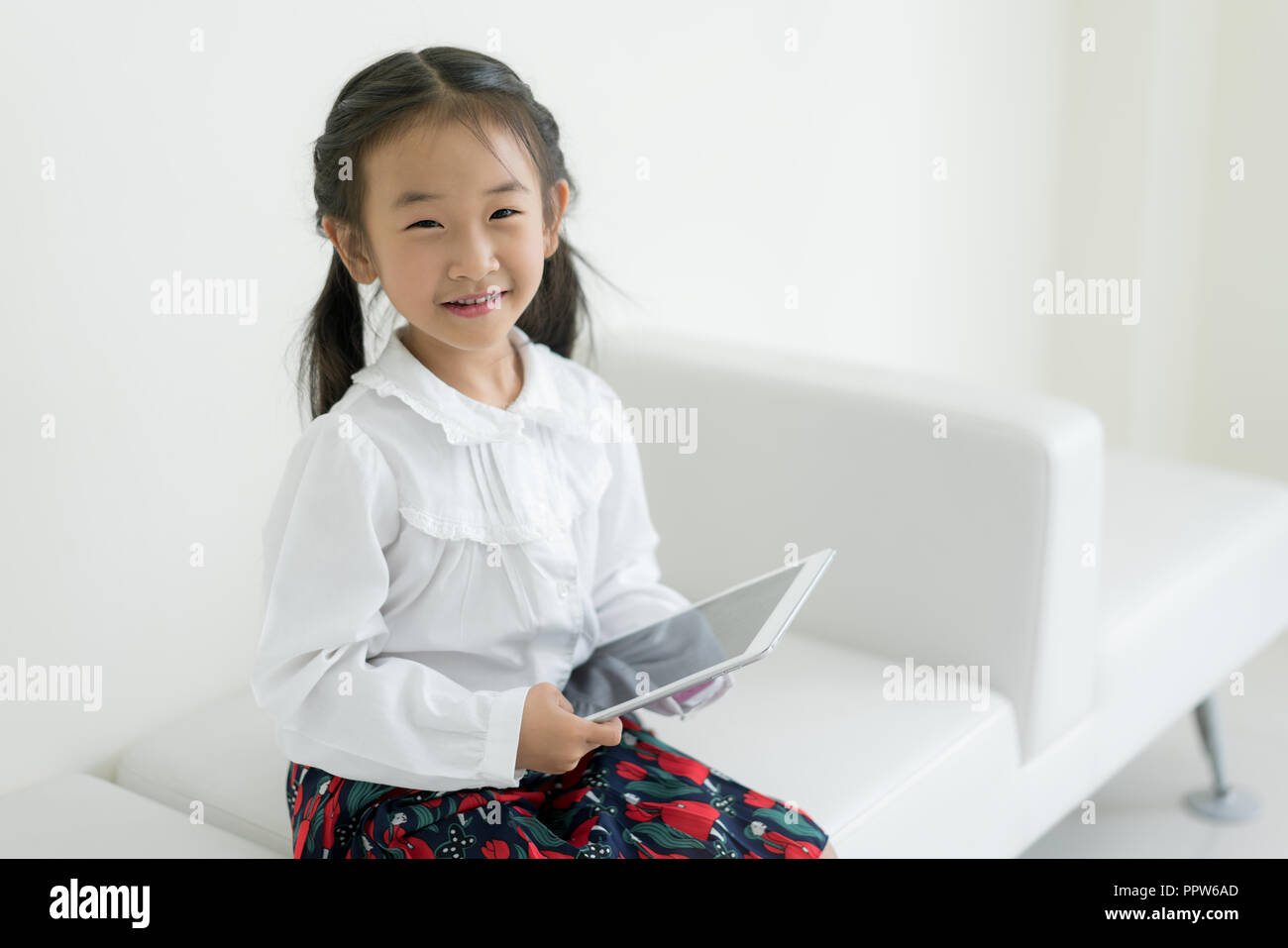 Asiatische Mädchen spielen digitale Tablette zu Hause. Bildung, Wissenschaft, Technologie, Kinder und Personen Konzept. Stockfoto