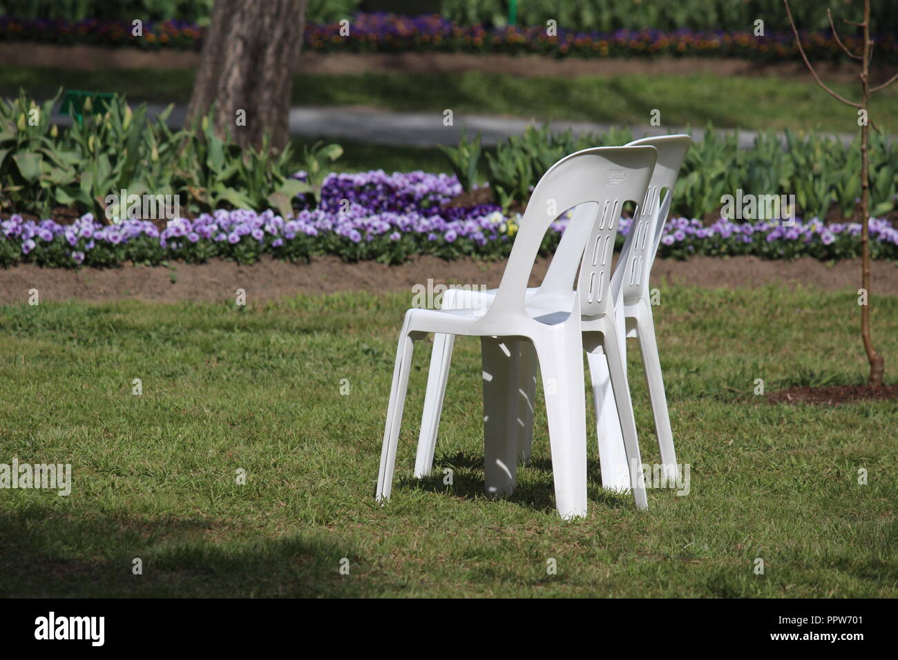 Ein paar Plastikstühle, die ein großes Picknick im Tulip Top Gärten, NSW, Australien Stockfoto