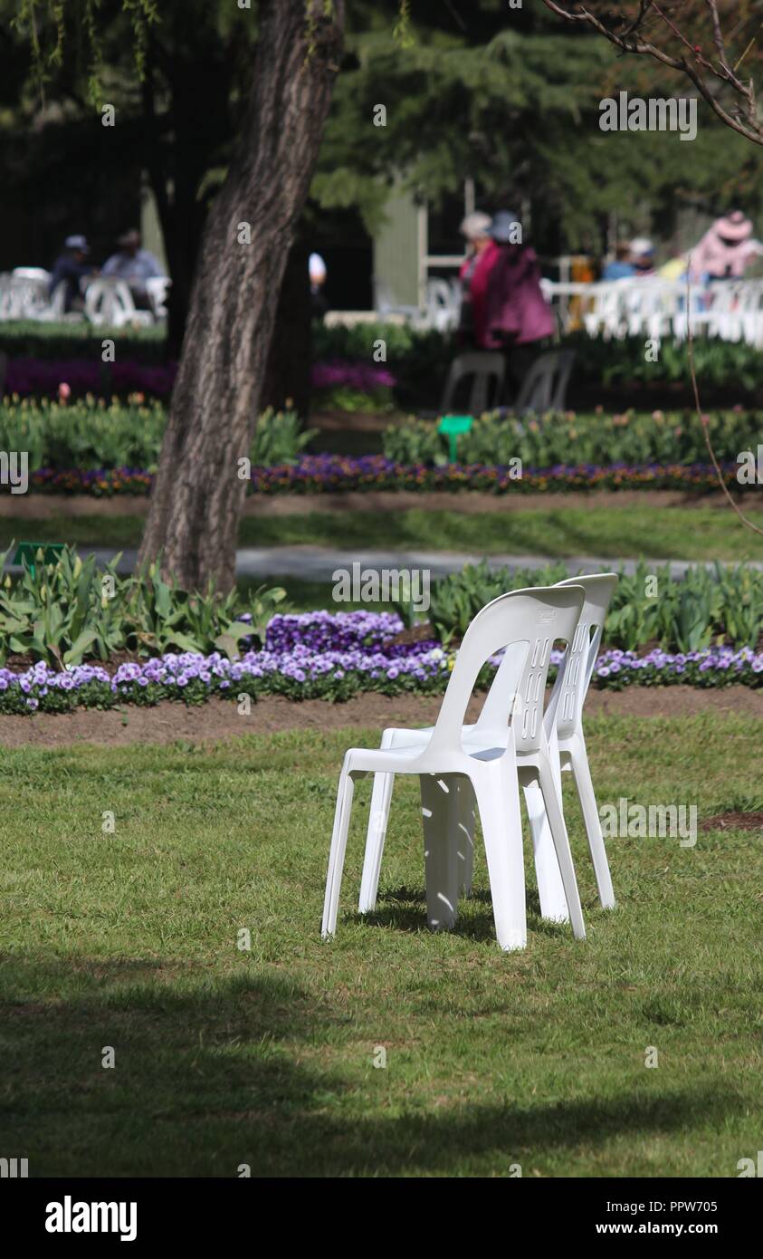 Ein paar Plastikstühle, die ein großes Picknick im Tulip Top Gärten, NSW, Australien Stockfoto