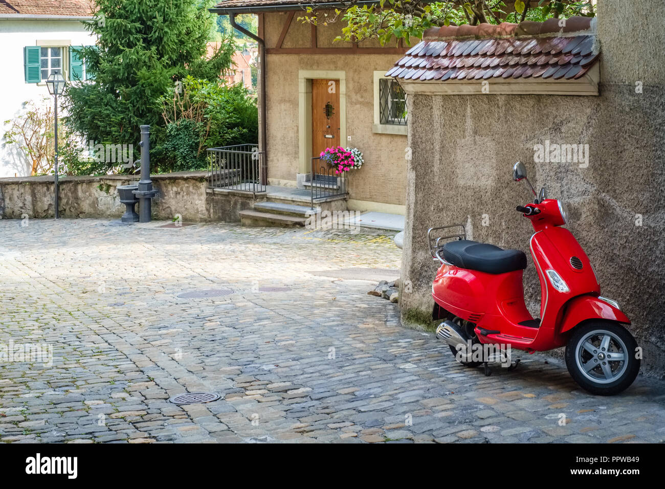 In einem Teil der Altstadt der Schweizer Stadt Thun, ein einsamer roter Roller wartet verwendet werden Stockfoto