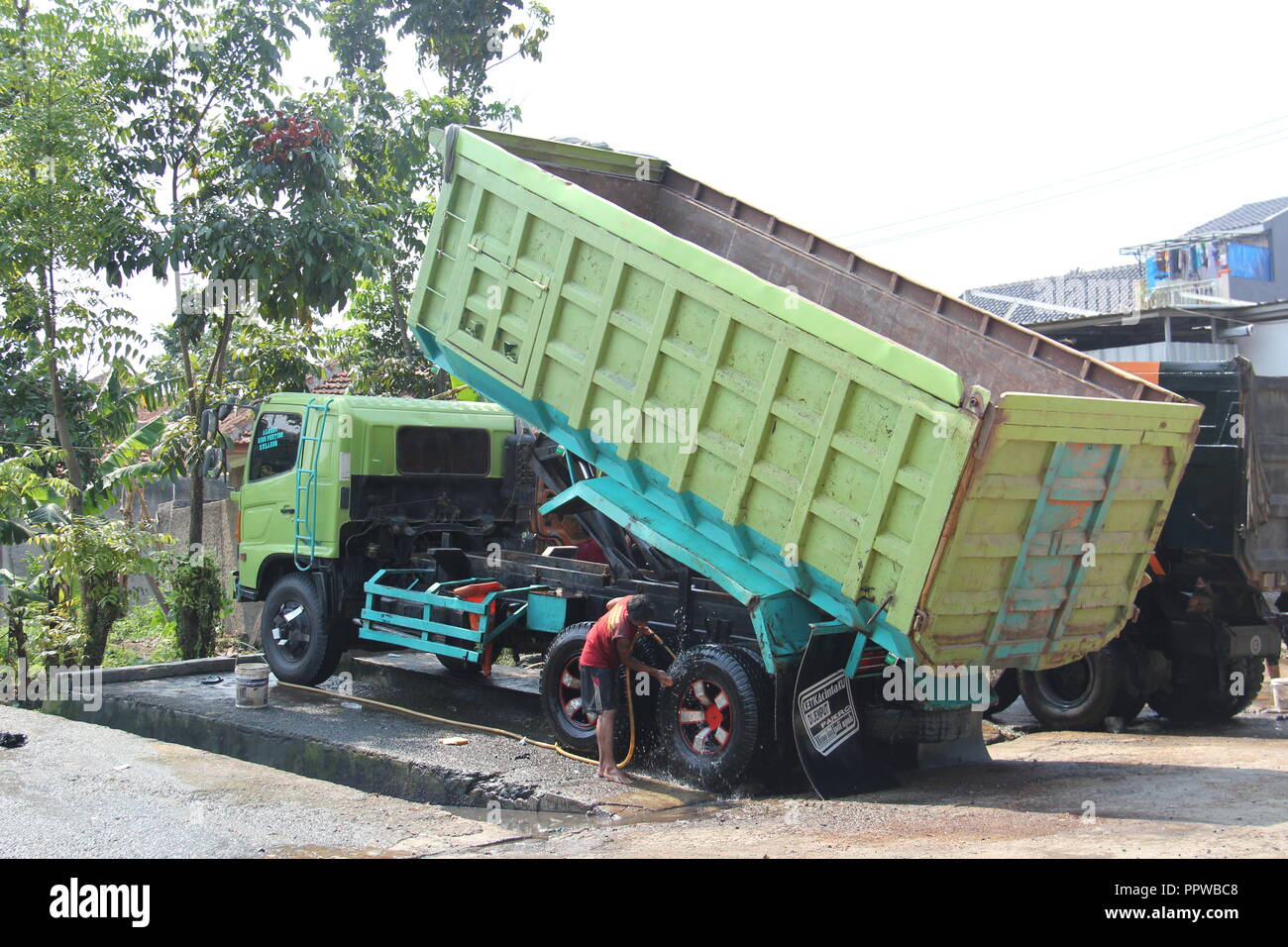 Lkw-Fahrer und Arbeiter Waschen des Staplers in Bandung, Indonesien, Südostasien. Stockfoto