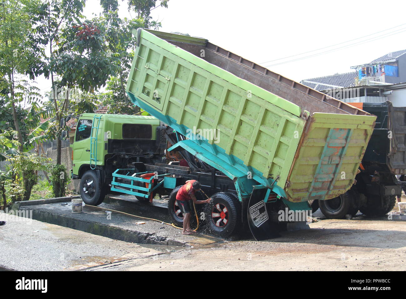 Lkw-Fahrer und Arbeiter Waschen des Staplers in Bandung, Indonesien, Südostasien. Stockfoto
