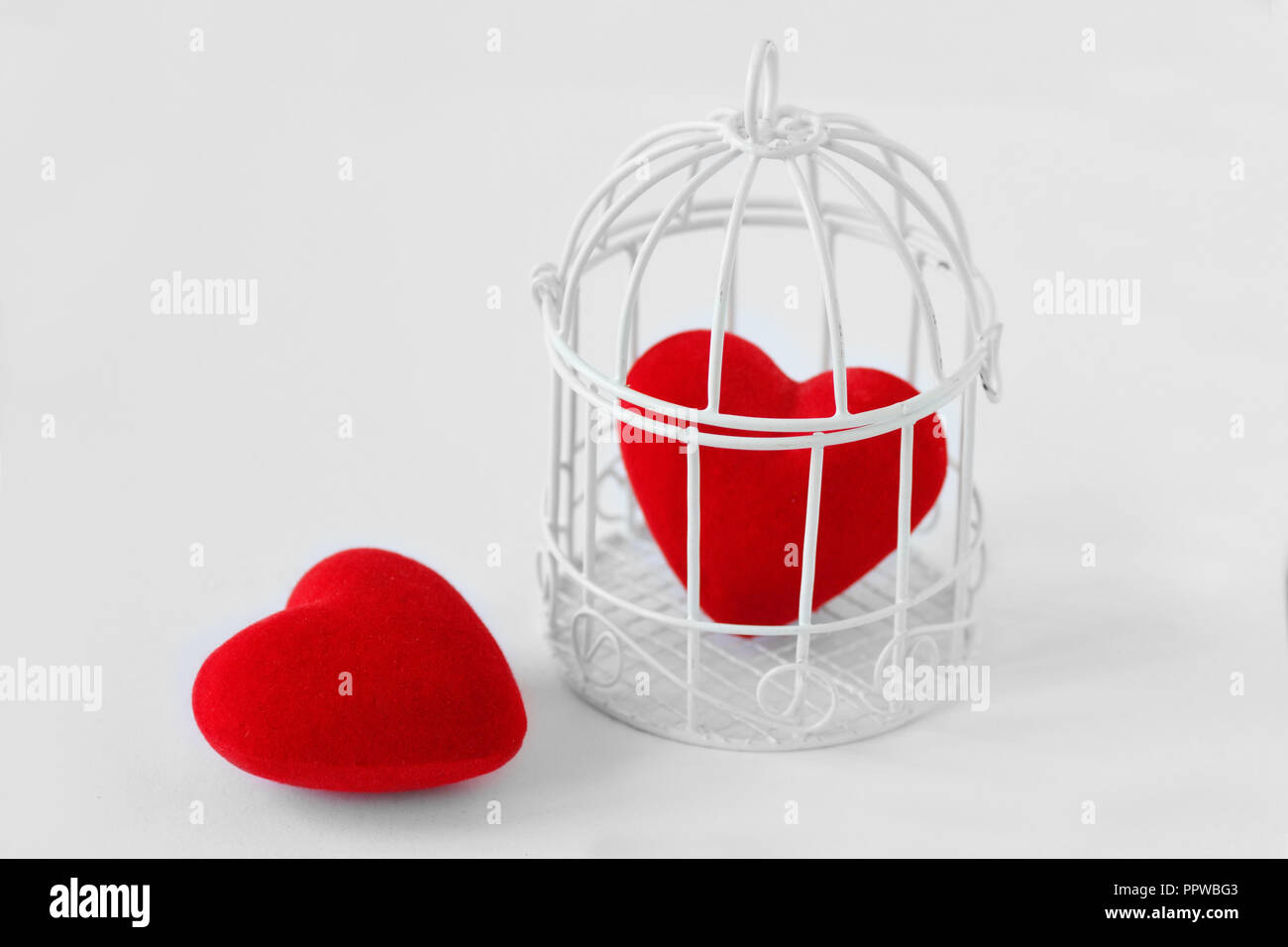 Herzen in einem Vogelkäfig und freiem Herzen - Liebe und Freiheit Konzept Stockfoto