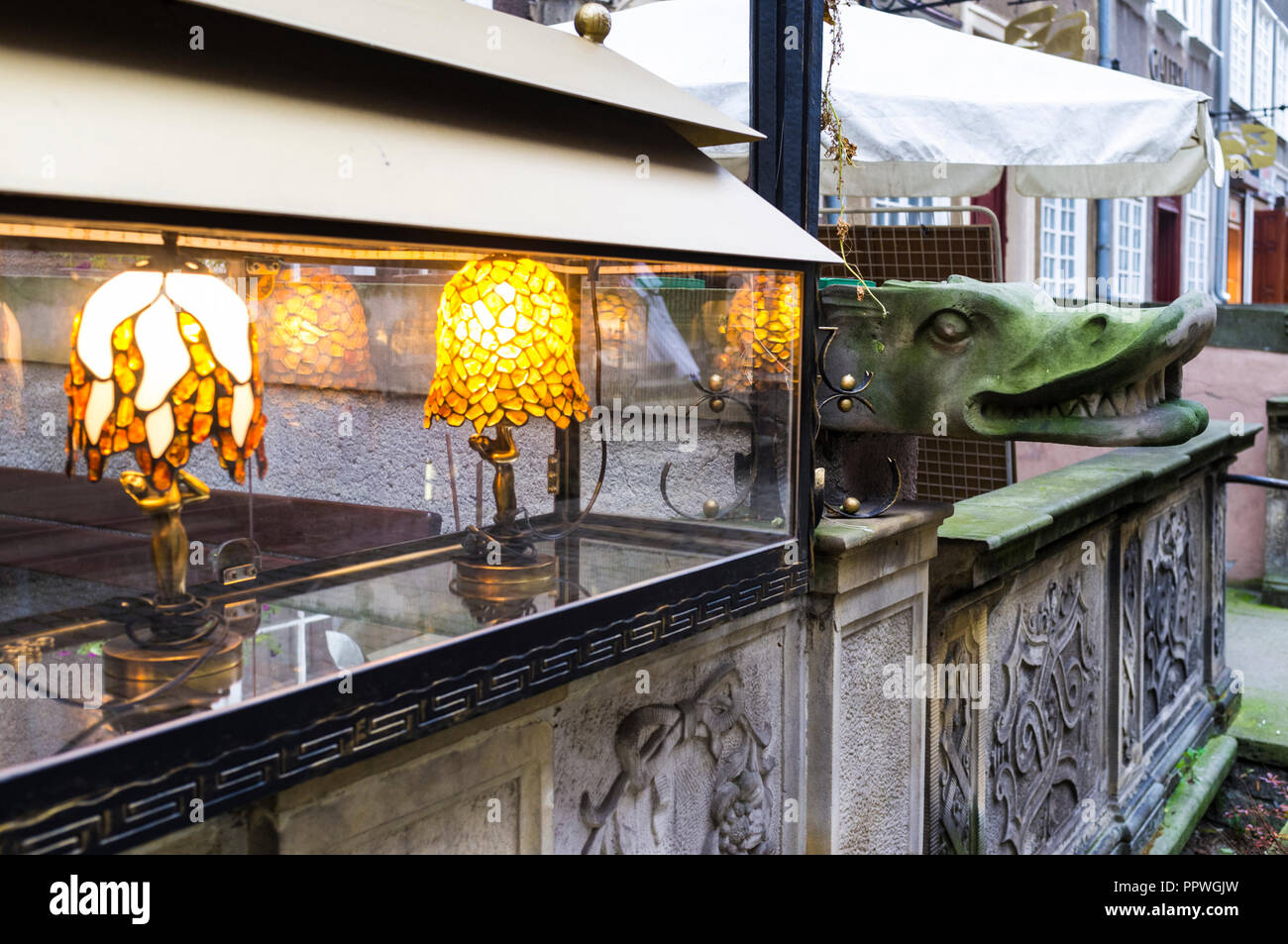 Danzig, Pommern, Polen: Gargoyle und beleuchtetes Display Cabinet von einem der vielen Bernstein Shops am St. Mary's Street (ul. Mariacka). Stockfoto
