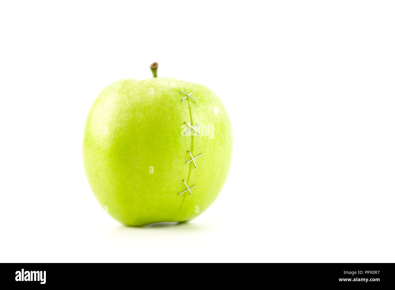 Green Apple mit Gehefteten riss auf weißem Hintergrund. Stockfoto