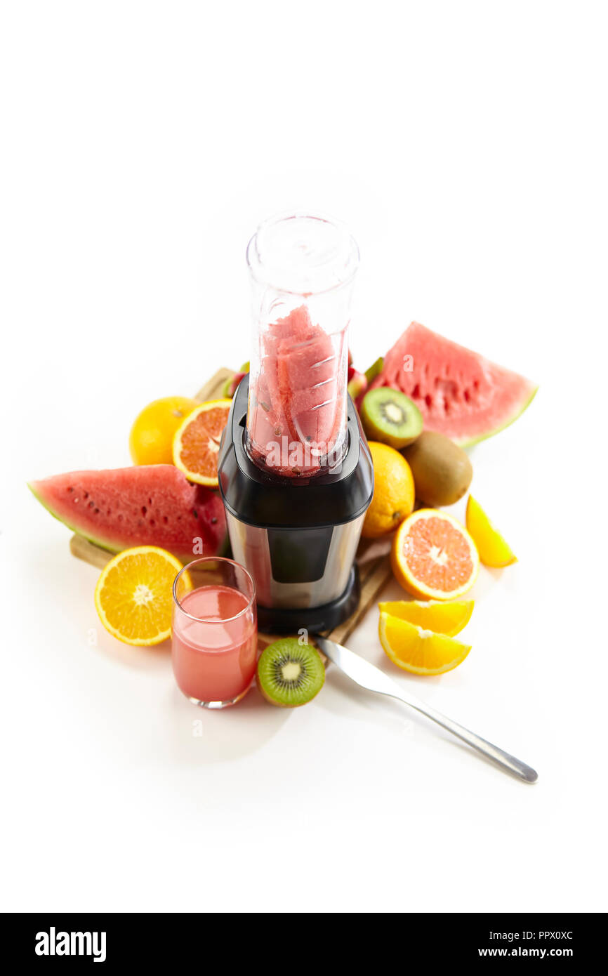 Obst, Säfte und Blender auf weißem Hintergrund. Stockfoto