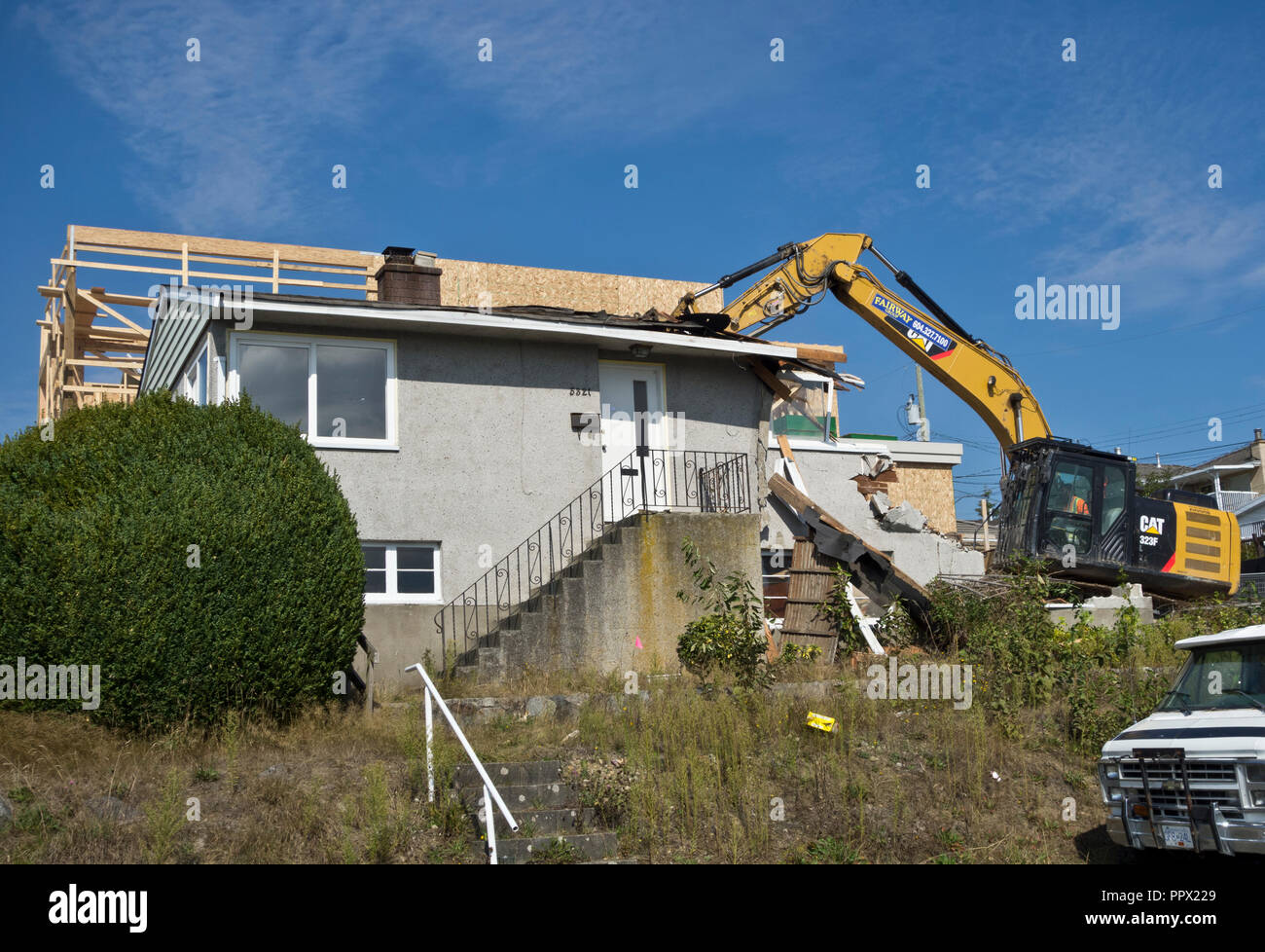 Ein 50er Jahre Bungalow in einer Metro Vancouver Vorort abgerissen wird, mit einem anderen Haus im Bau nebenan. Stockfoto