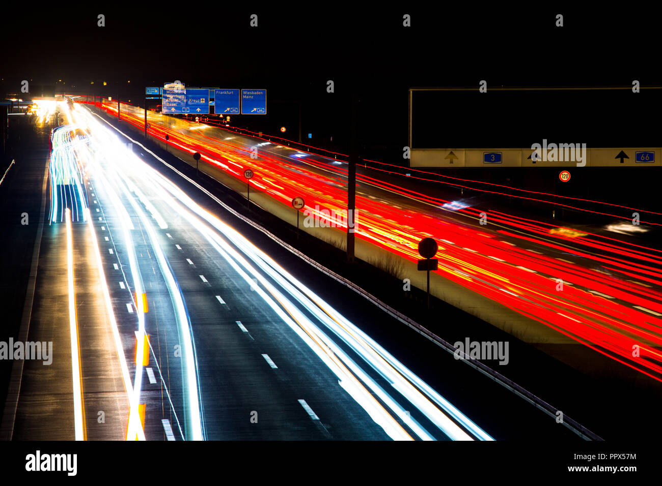Nacht Verkehr Wanderwege auf einer deutschen Autobahn, Bewegungsunschärfe, mit Lastwagen, Autos und Bussen, in Deutschland, A3 Wiesbadener Kreuz Stockfoto