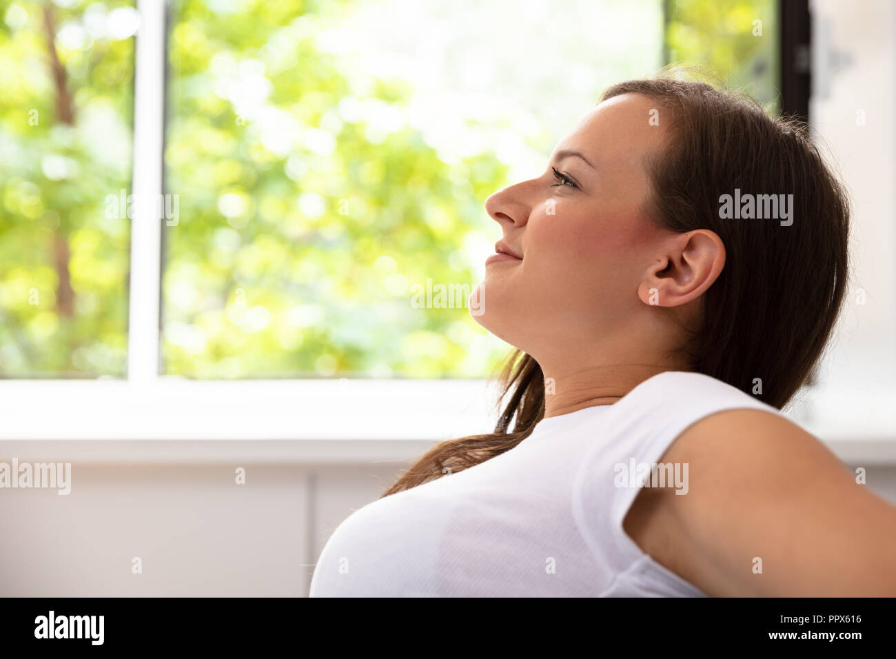 Nahaufnahme einer Lächelnden jungen Frau zu Hause Stockfoto