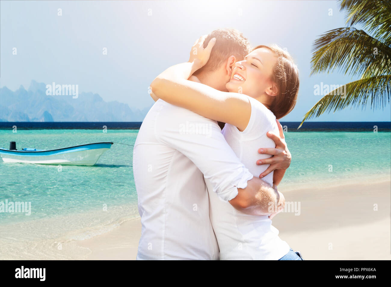 Reizende junge Paar umarmen einander am Strand Stockfoto