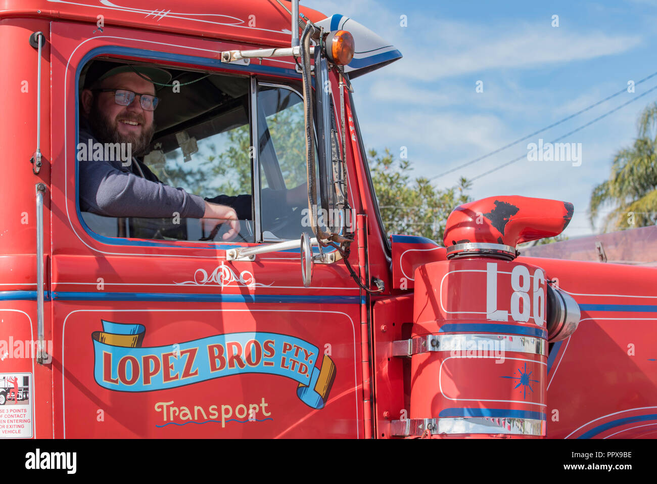 Einen lächelnden Fahrer sitzt in der Kabine der ersten Lopez Bros fleet Truck, 1982 Weiße Straße Boss Prime Mover, die noch im aktiven Dienst ist heute Stockfoto