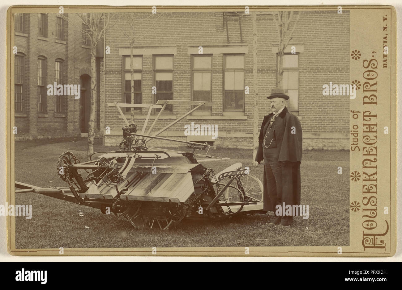 Mann mit einem Stück von Landmaschinen posiert; Houseknecht & Brüder; über 1885, Silbergelatineabzug Stockfoto