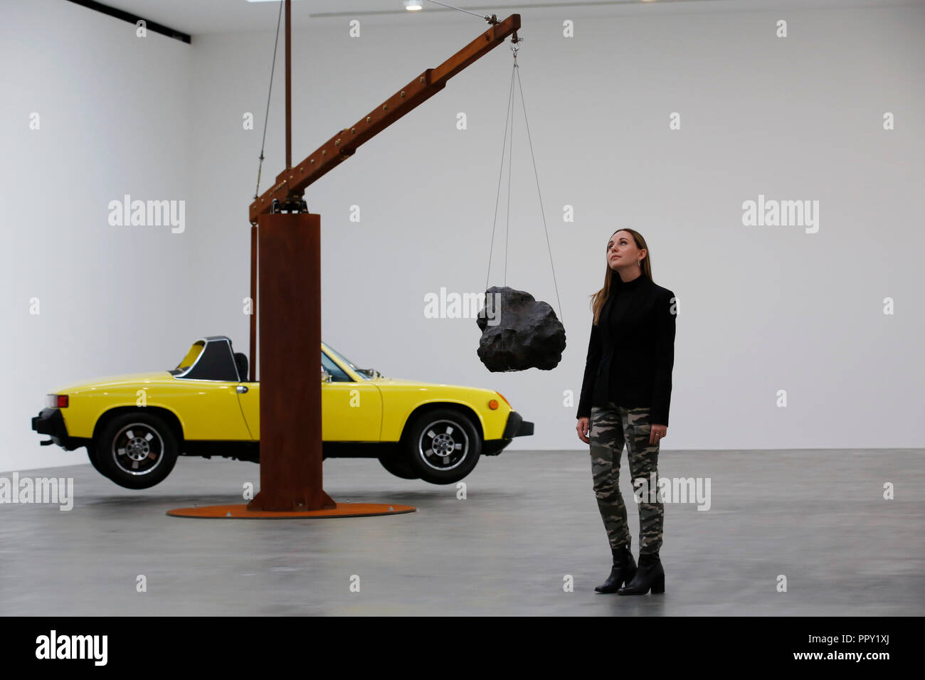 London, Großbritannien. 28. Sep 2018. Eine Galerie Mitarbeiter wirft mit Artwork Artist Chris Burden "Porsche mit Meteorit" Teil des 'Measured' Ausstellung in der Gagosian Gallery in London Freitag, 28. September 2018. 1974 restauriert Porsche 914 mit einem Gewicht von 993.4 kg (2.190 llbs) ist-bung im Gleichgewicht mit 176,9 kg (390 lbs) nikel Bügeleisen Meteoritenstaub nach. Die Ausstellung läuft bis 26. Januar. Foto: © Lukas MacGregor Credit: Lukas MacGregor/Alamy leben Nachrichten Stockfoto