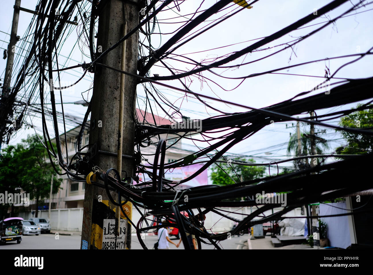 Unordentliche elektrische Leitungen auf einer Straße in Chiang Mai, Thailand Stockfoto