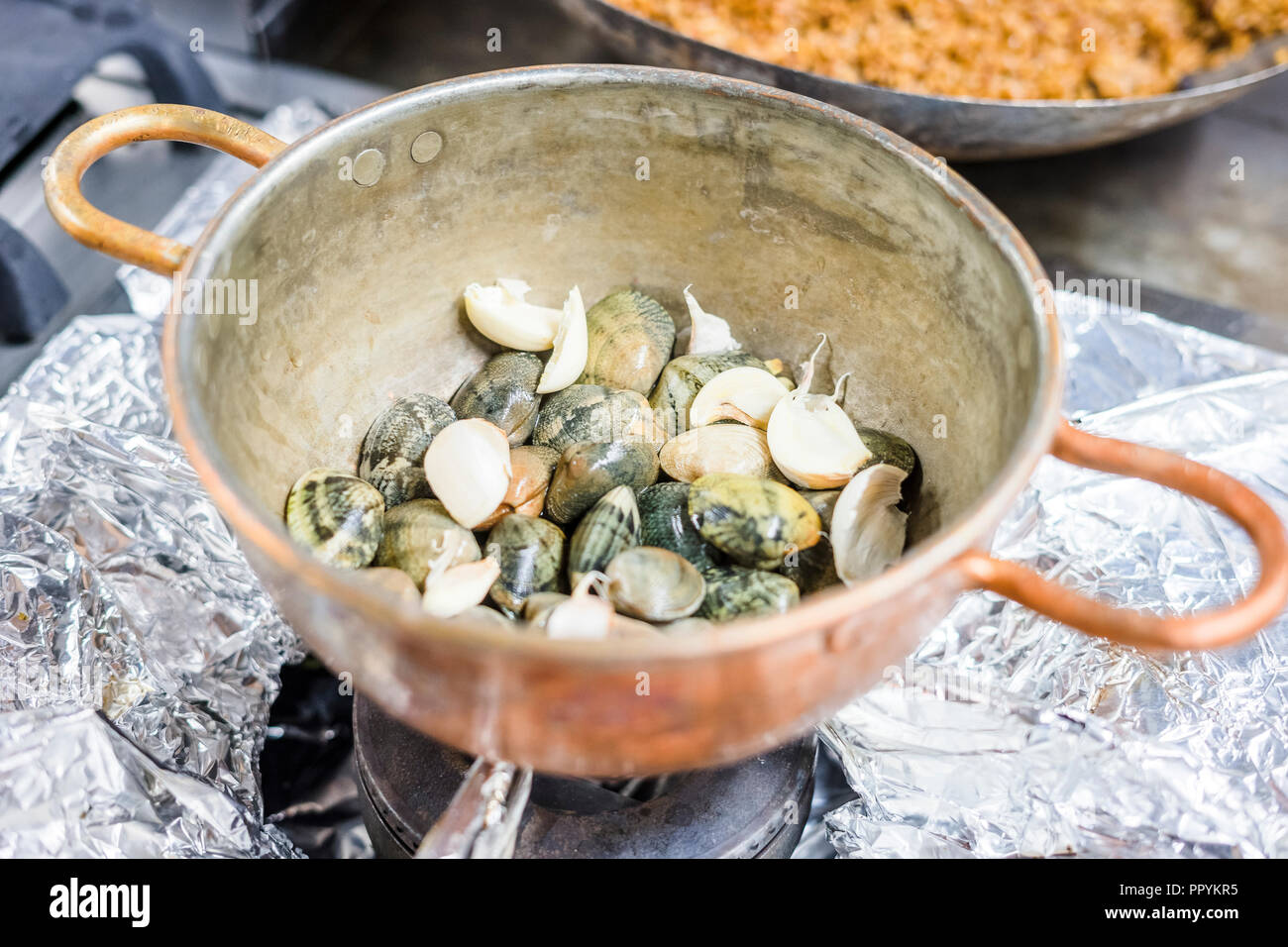 Teil der Muscheln in einem kupfernen Topf auf Gas Herd Stockfoto