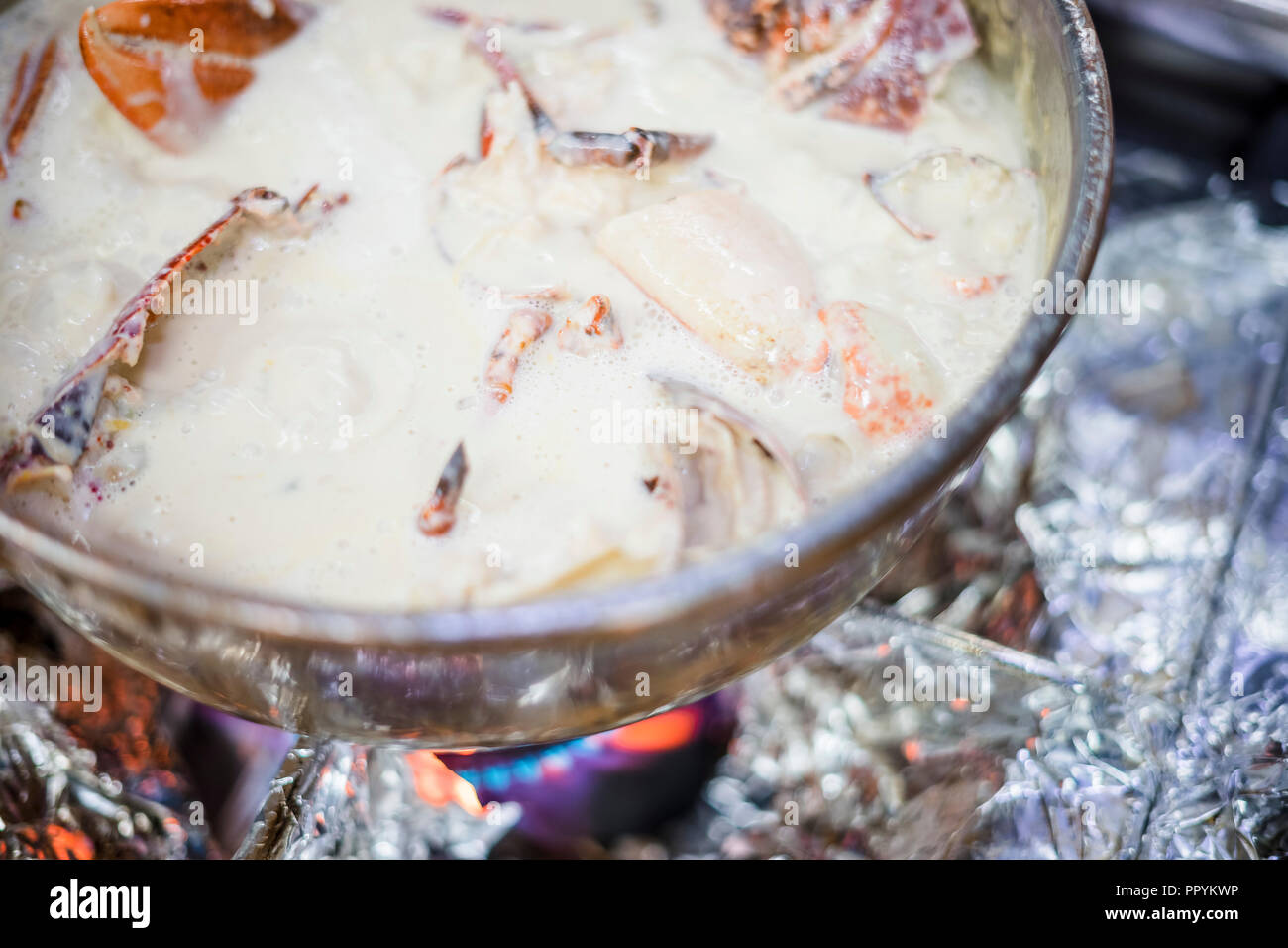 Hummersuppe auf Basis von Milch und Rotwein in Kupfer Topf zubereitet Stockfoto