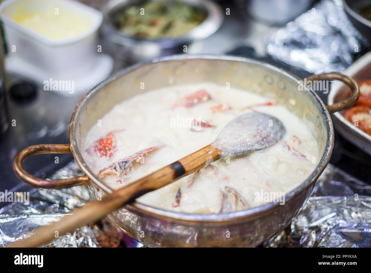 Hummersuppe auf Basis von Milch und Rotwein in Kupfer Topf zubereitet Stockfoto