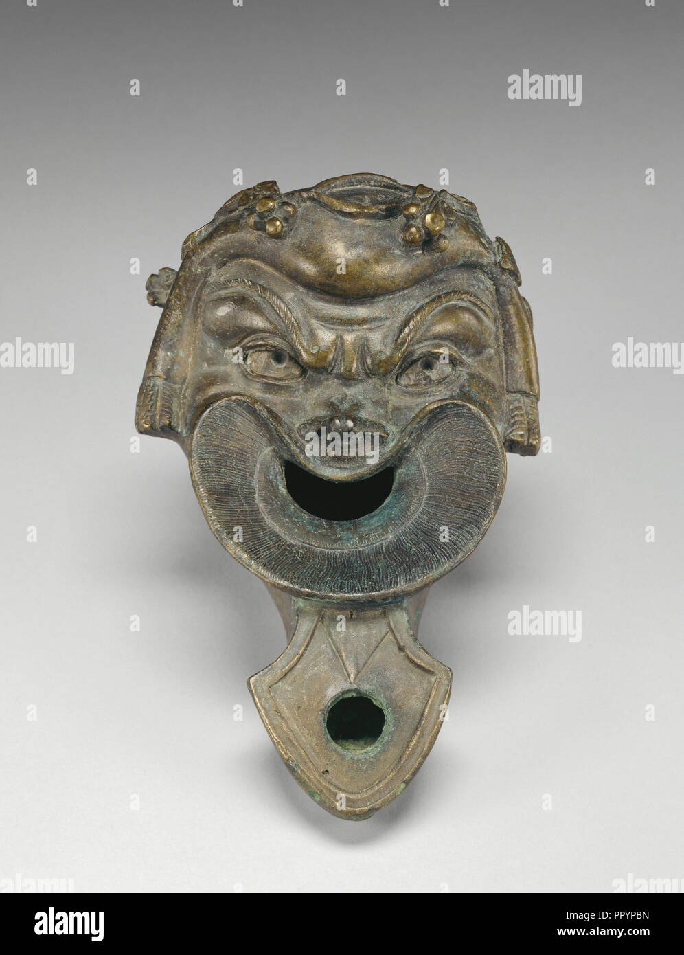 Lampe in Form einer komischen Maske; Römisches Reich; 75-125; Bronze; 6,9 x 12,5 cm, 2 11,16 × 4 15,16 in Stockfoto