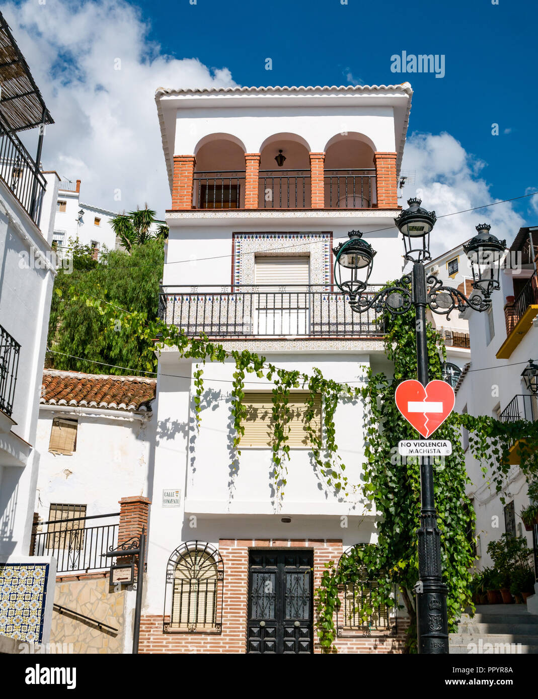 Hübsche weiße Häuser mit Null Toleranz gegen häusliche Gewalt Zeichen in Spanisch, Canillas de Acientuna, Axarquia, Andalusien, Spanien Stockfoto