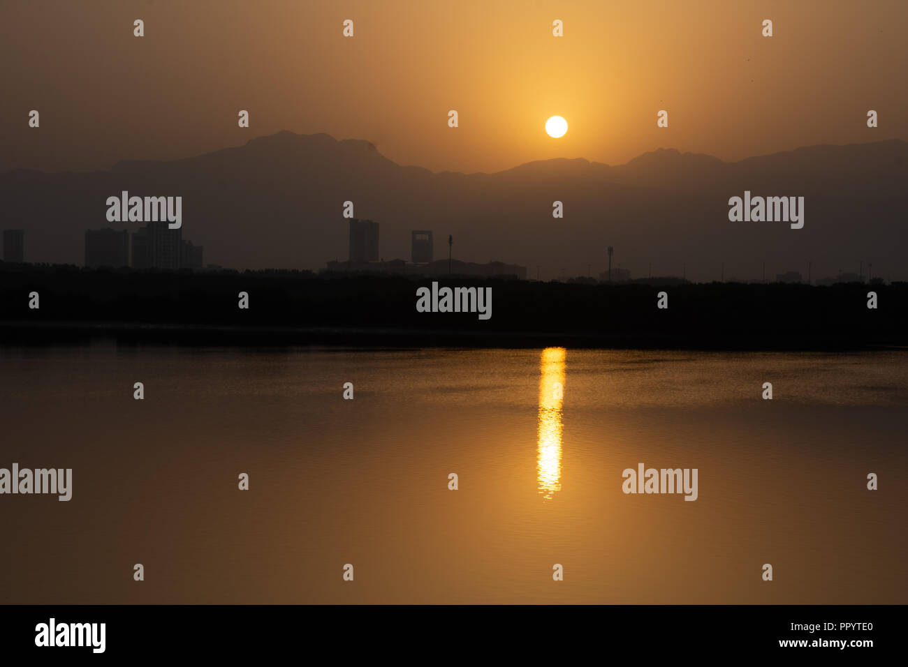 Sonnenaufgang über dem jebal Jais Berg und Ras Al Khaimah Stadt Stockfoto