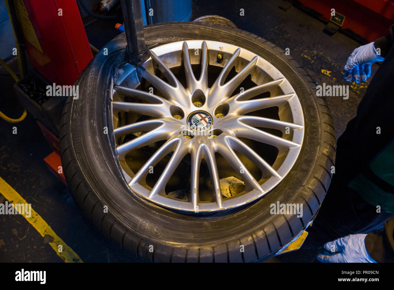 Reifen Monteur/Mechaniker Montage/einen neuen Reifen (Goodyear) auf einem  Auto / PKW Rad/Räder Leichtmetallfelge mit einer Maschine. UK. (102  Stockfotografie - Alamy
