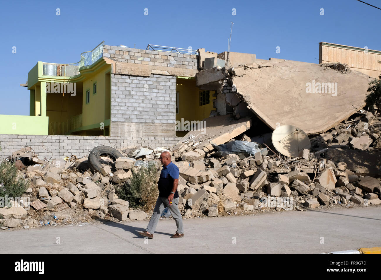 Zerstört (rechts) und umgebaute Wohnhaus in Bashiqua, Nord Irak, Kurdistan Stockfoto