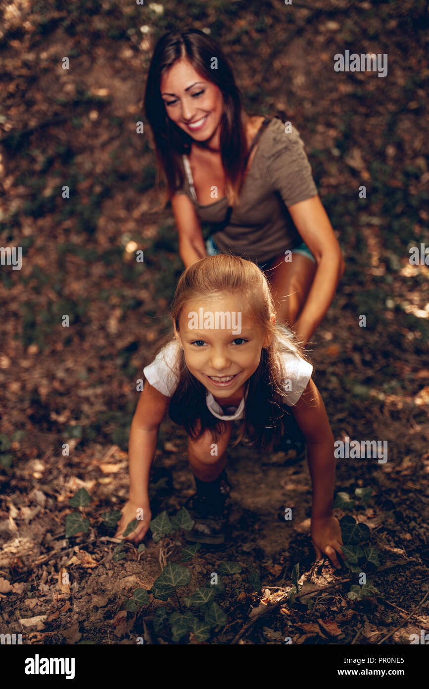 Schöne junge Mädchen Spaß haben im Wald. Mutter auf ihr. Stockfoto