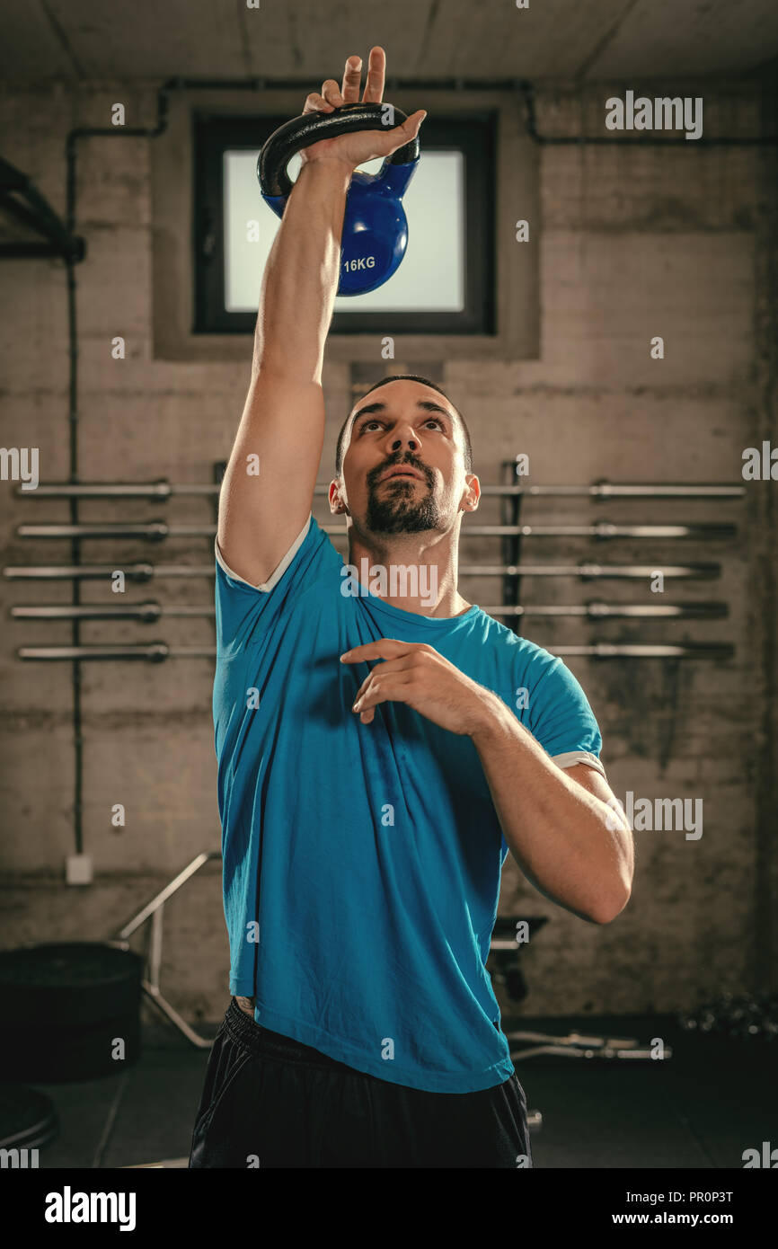 Junge muskulöse Mann bereit, mit kettlebell im Fitnessstudio zu trainieren. Stockfoto