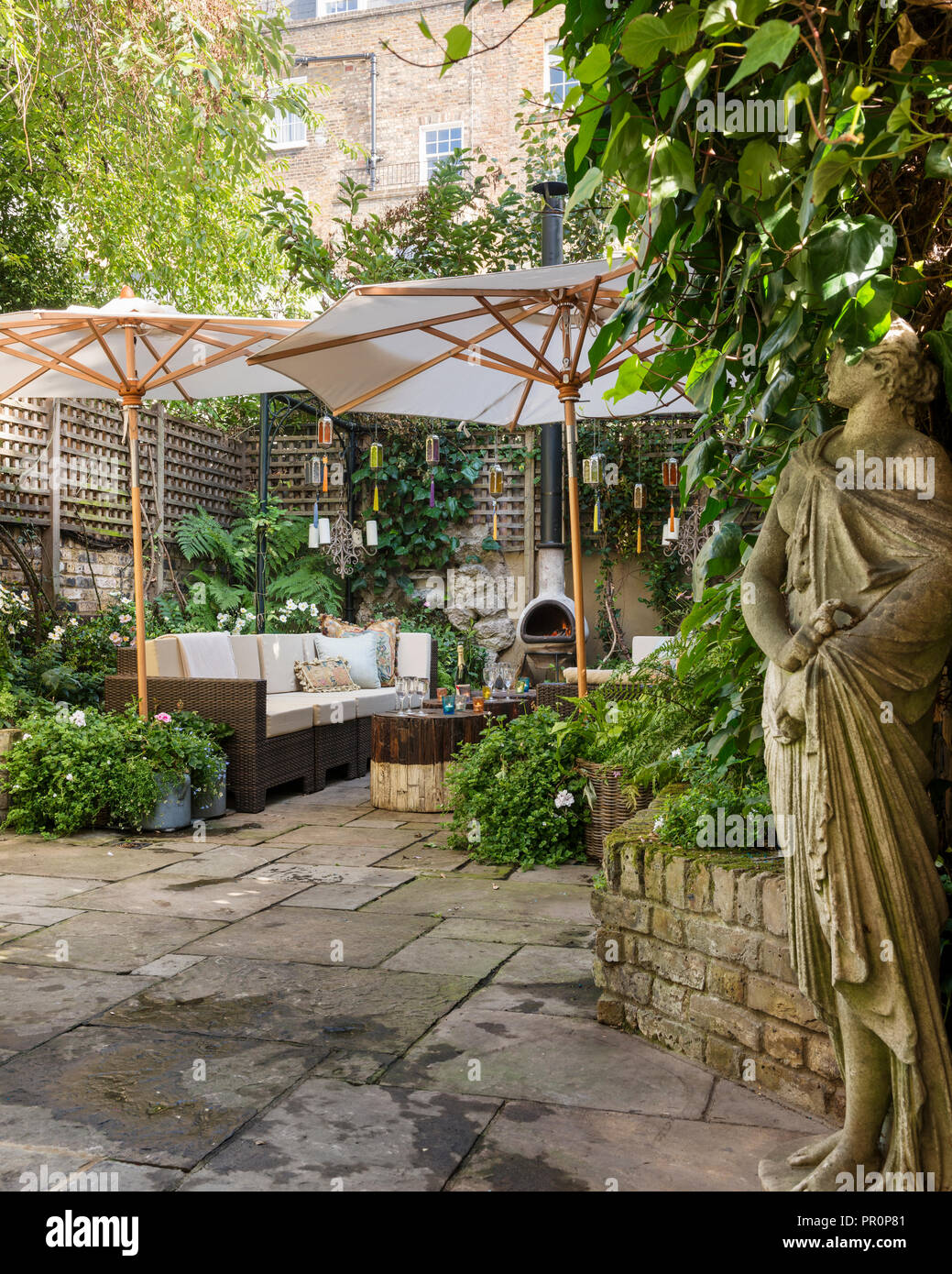 Garten Skulptur in London Garten im Innenhof mit einem Gitter umzäunt und schattigen mit Sonnenschirmen Stockfoto