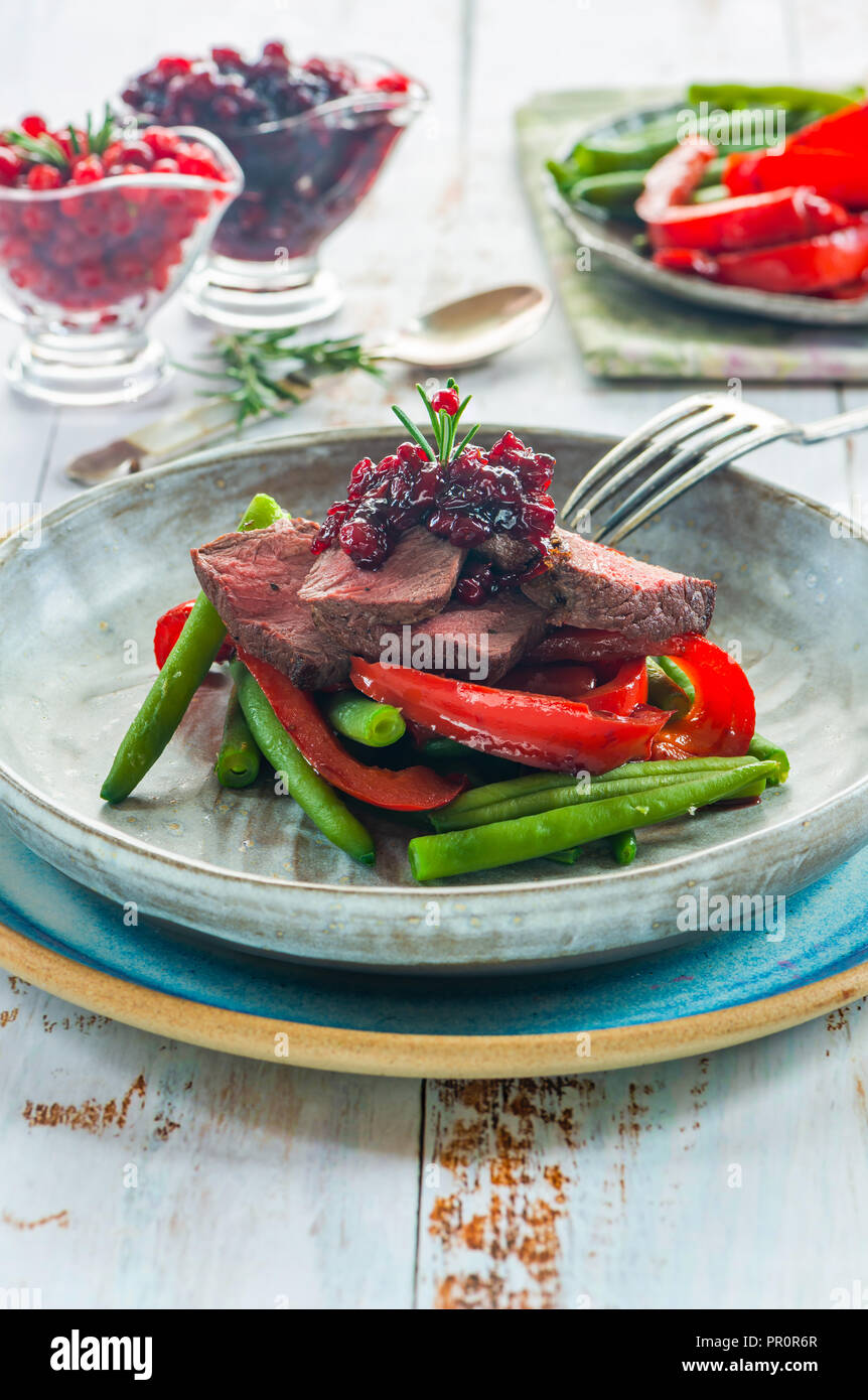 Geschnetzeltes Wildbret Steak Sauce mit Preiselbeeren, gebratene Paprika und grünen Bohnen Stockfoto