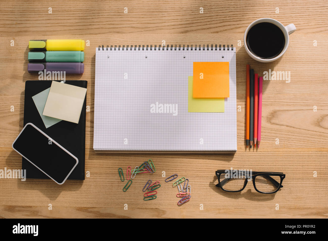 Blick von oben auf die Büroartikel, stick Noten, Smartphone, Büroklammern, Notebook und Tasse Kaffee Stockfoto