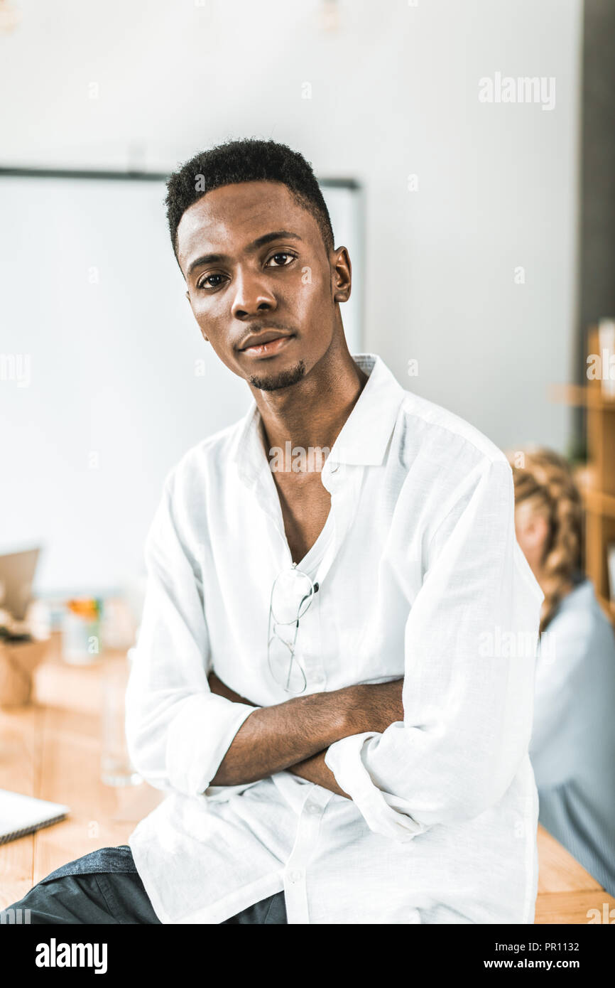 Portrait von nachdenklich afrikanische amerikanische Geschäftsmann mit verschränkten Armen an Kamera suchen Stockfoto