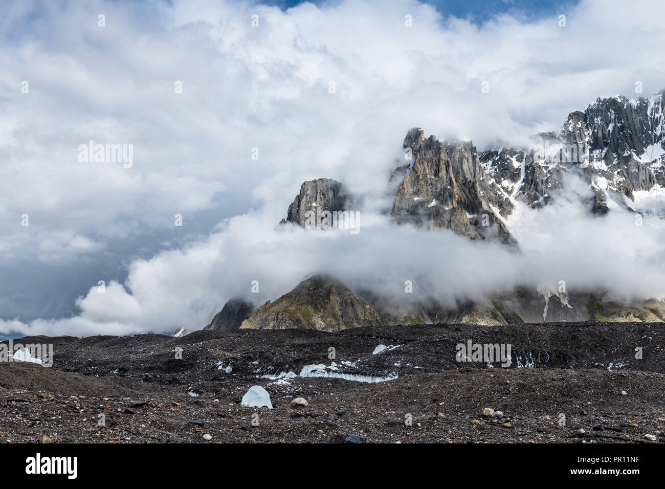 Zerklüftete Gipfel von Biarchedi Gruppe von Bergen erscheinen hinter Wolken, Baltoro Galcier, Karakorum, Pakistan Stockfoto