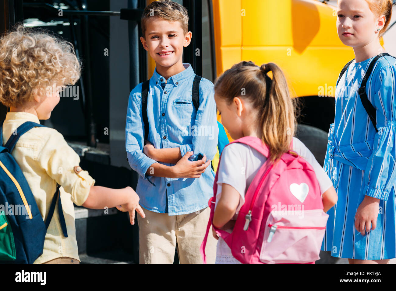 Gruppe von adorable Schüler chatten in der Nähe der Schule Bus Stockfoto