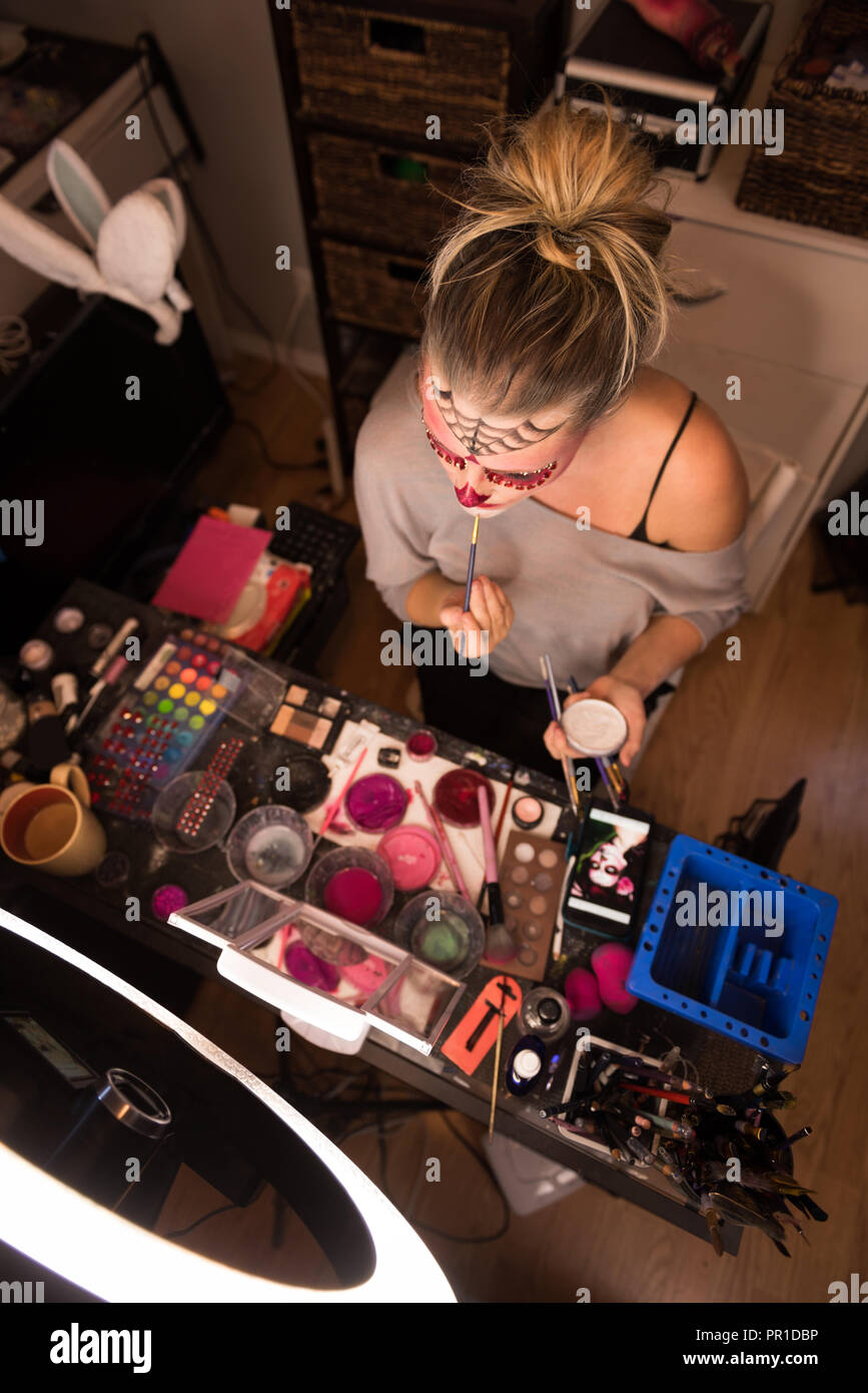 Frau Malerei ihr Gesicht mit Bürste Stockfoto