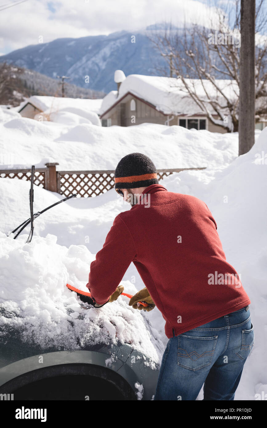 Mann Reinigung Schnee vom Auto im Winter Stockfoto