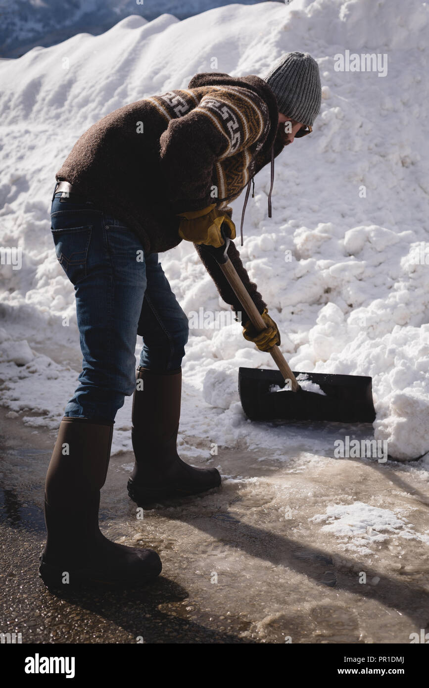 Mann Reinigung Schnee mit Schneeschaufel Stockfoto