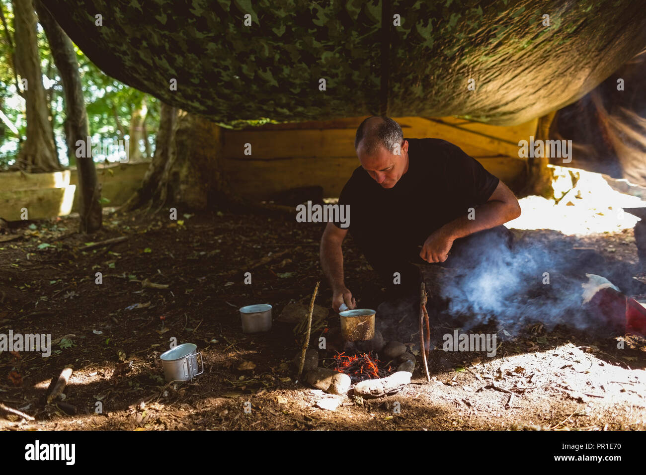 Mann Kochen bei Boot Camp Stockfoto