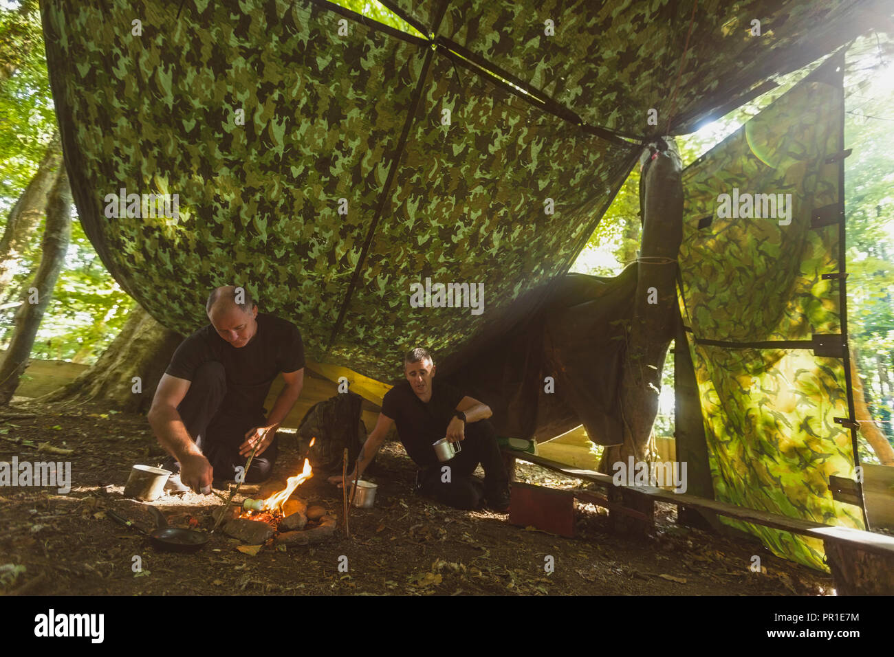 Mann Beleuchtung Feuer am Boot Camp Stockfoto