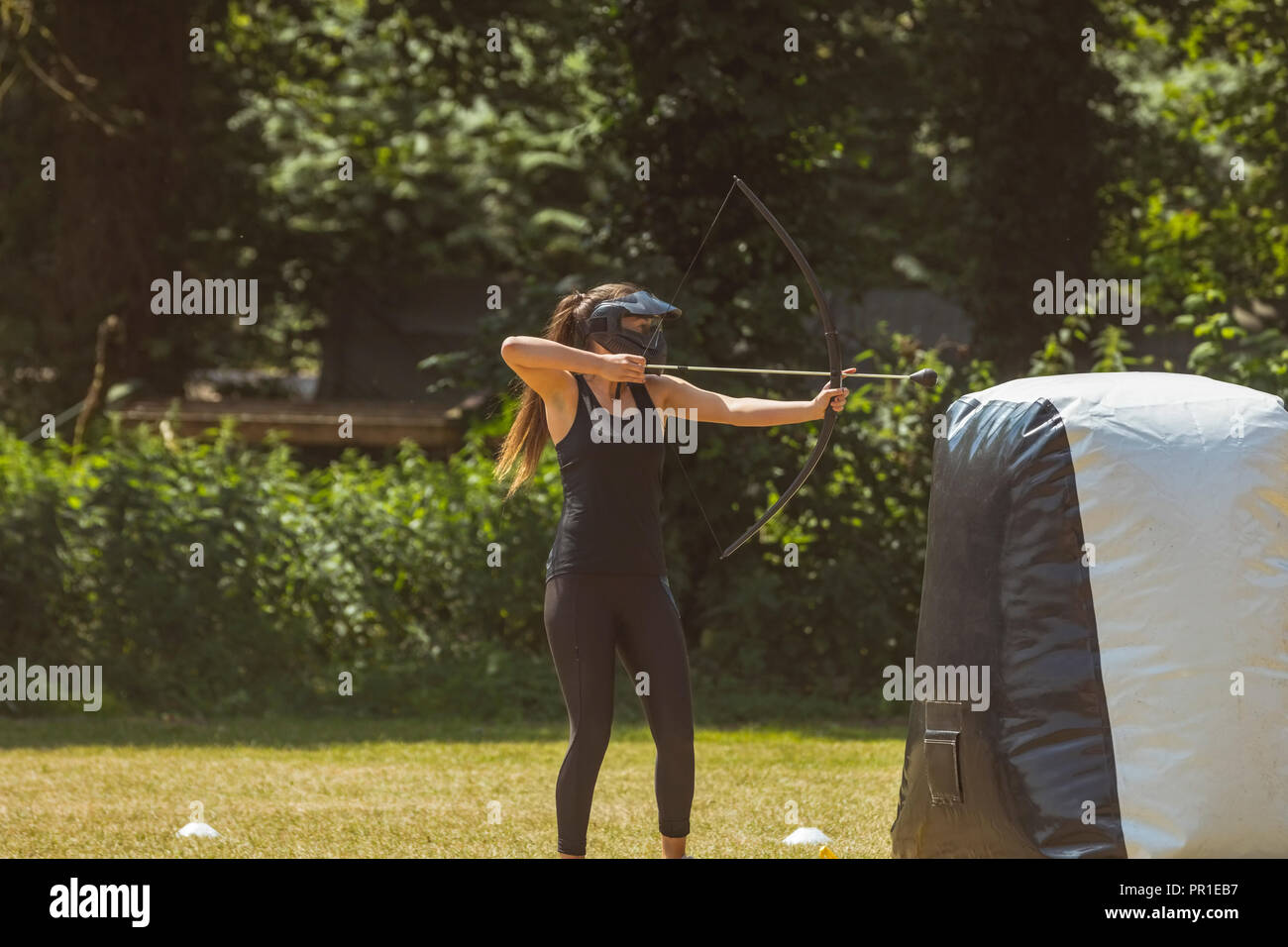 Frau üben Bogenschießen auf Boot Camp Stockfoto