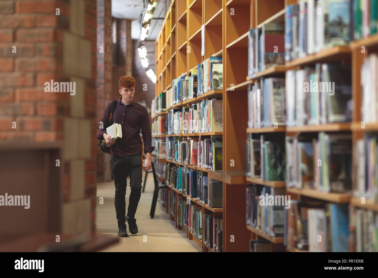Student mit Bücher wandern in Bibliothek Stockfoto
