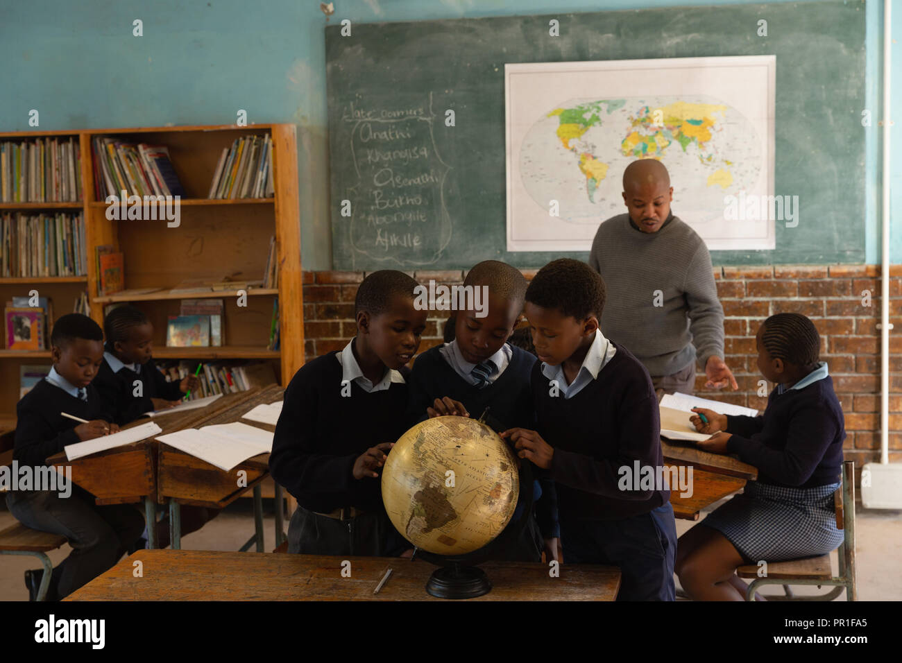 Schoolkids mit Globe im Klassenzimmer Stockfoto