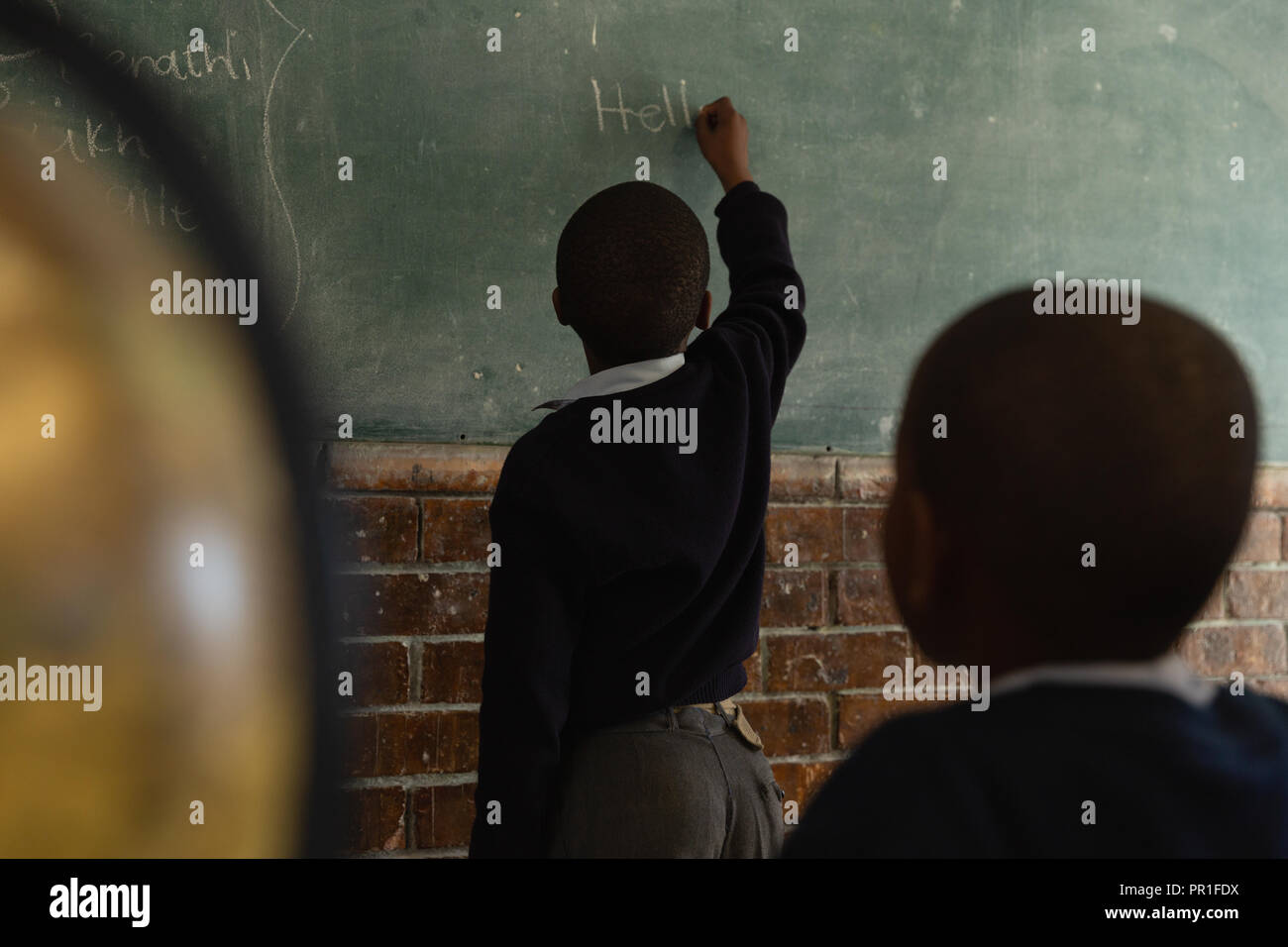 Schüler schreiben auf der Tafel im Klassenzimmer Stockfoto