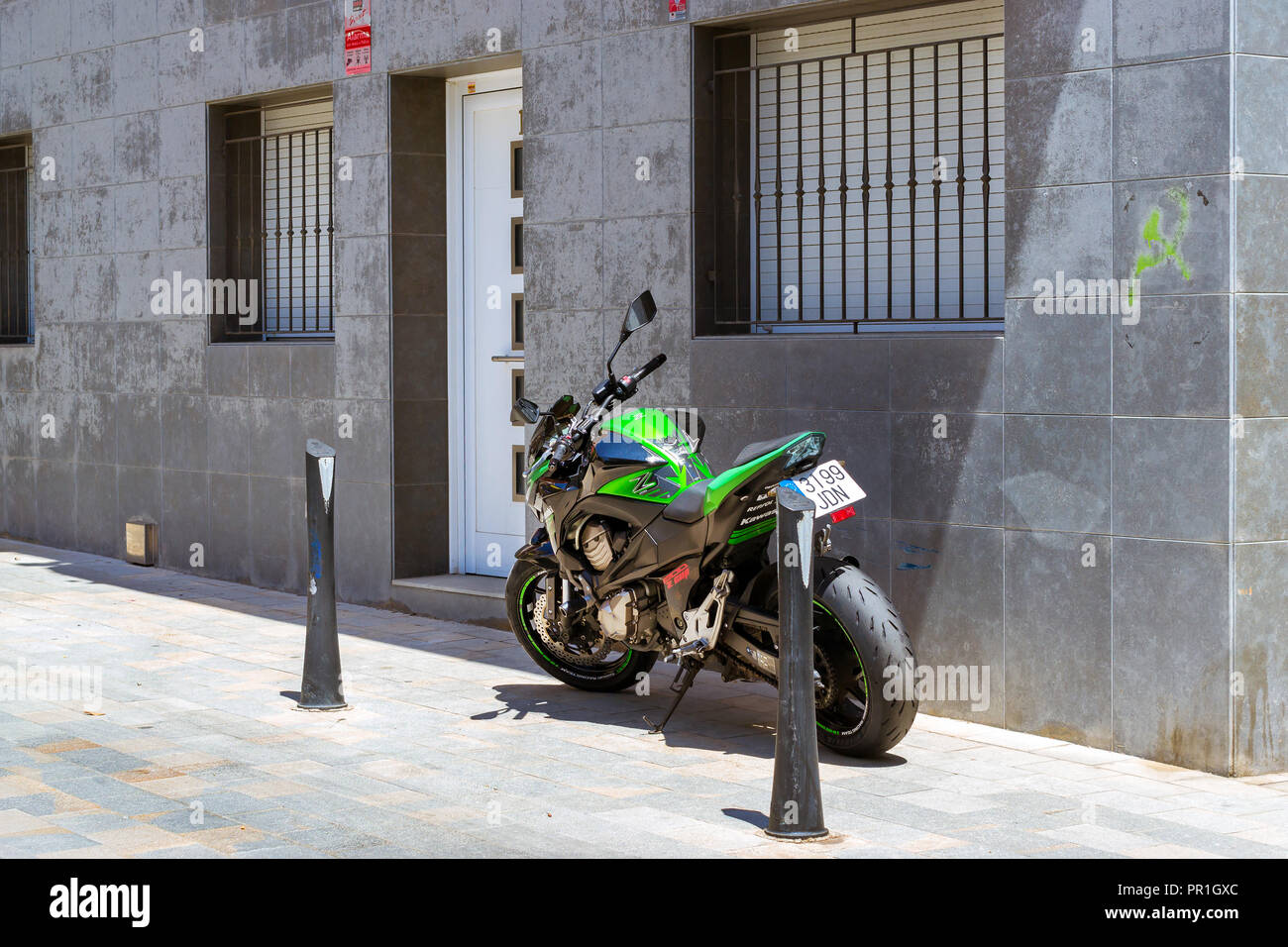 Blanes, Spanien - 31. Mai, 2018: Sport Motocross Motorrad Kawasaki in der Fußgängerzone geparkt. Die engen Gassen der Spanischen Resort. Verlassene Architektur der Spanischen Beach Resort. Costa Brava, Katalonien Stockfoto