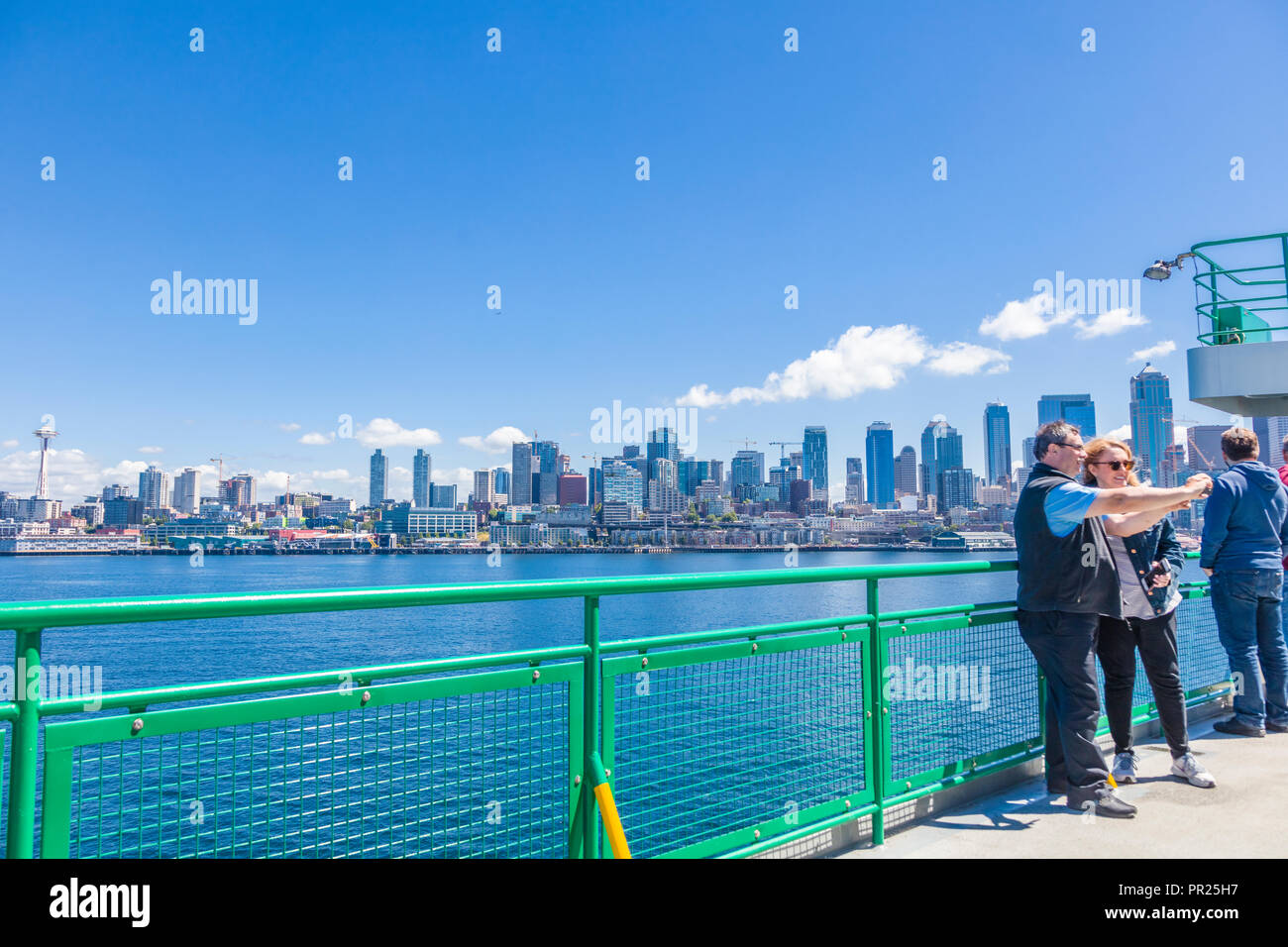 Seattle Washington City Skyline mit Fahrgästen im Vordergrund auf dem Deck der Fähre im Puget Sound geht nach Seattle, Washington Stockfoto