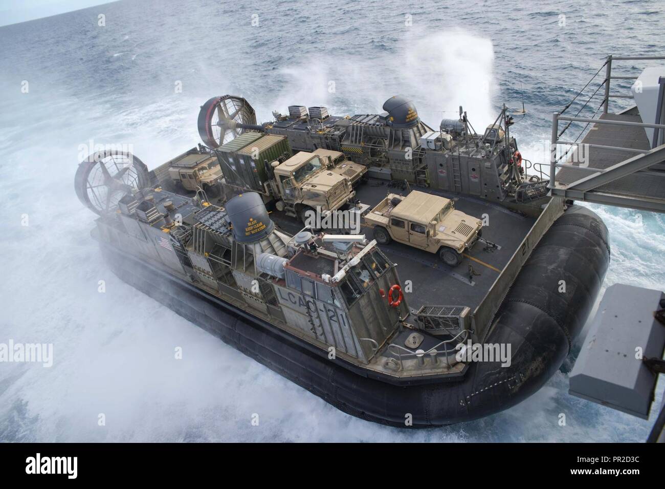 CORAL SEA (23 Juli 2017) Landing Craft air cushion (LCAC) 21, Naval Beach (NBU) 7, Ansätze der gut Deck des Amphibious Assault ship USS BONHOMME RICHARD (LHD6) als Marines der 31 Marine Expeditionary Unit (MEU) Rückkehr von Training mit der Australischen Armee in der Shoalwater Bay Bereich Schulungen als Teil der Talisman Sabre 17 zugeordnet. Talisman Säbel ist eine zweijährige US-australischen bilateralen Ausübung gehalten vor der Küste von Australien gedacht, um die Interoperabilität zu erreichen und den USA - australische Bündnis stärken. Stockfoto