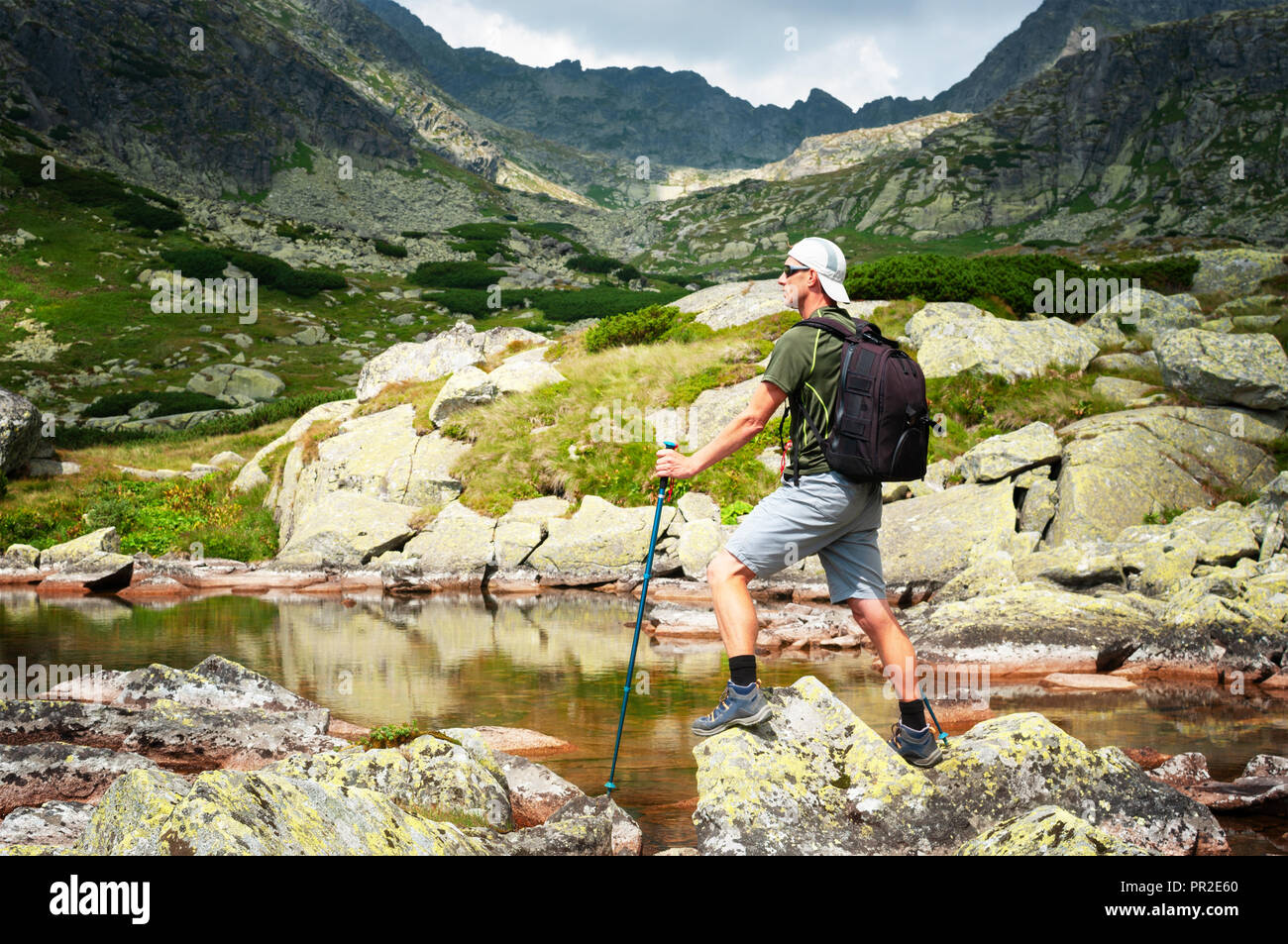 Wanderer mit Rucksack auf die Felsen in den Bergen Stockfoto