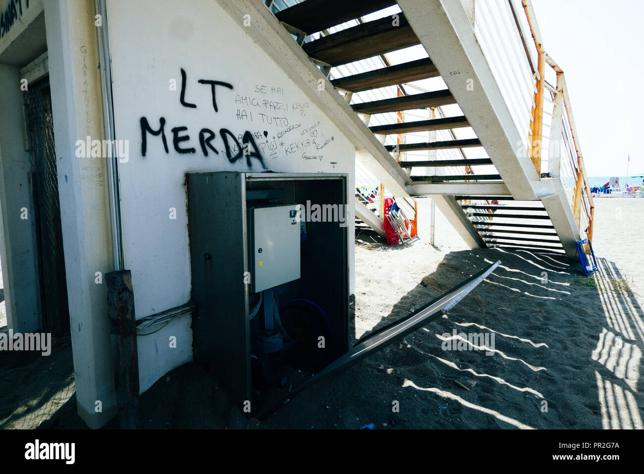 Ende einer Brücke mit Graffiti und ein ausgedienter Aufzug in Fondi, Latina, Italien. Am Strand. Stockfoto