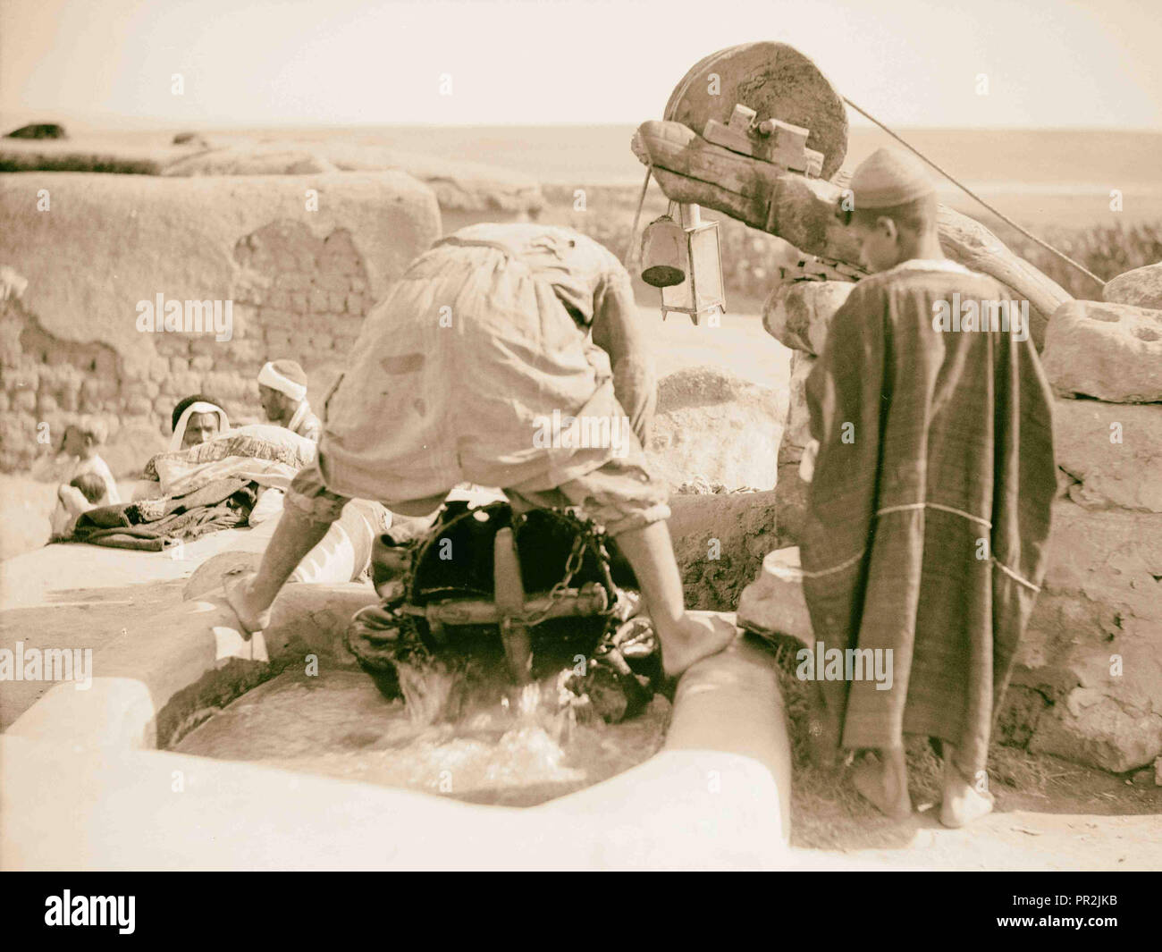 Zeichnung Wasser durch Kamel- und Kuh macht. Haut Schaufel in Wasser Tränke. Seitenansicht von der Umlenkrolle. 1920, Naher Osten, Israel Stockfoto